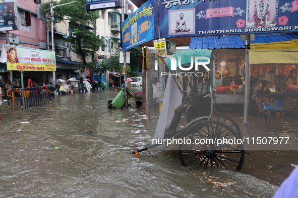 Rickshaw pullers wait for customers during a water-logged street after heavy monsoon rain in Kolkata, India, on August 24, 2024. 