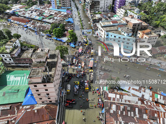 An aerial view shows volunteers transporting relief materials for flood-affected people in the Mohipal area of Feni district in Chittagong d...