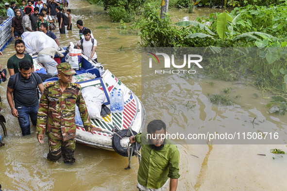 Volunteers and Bangladesh army personnel transport relief material for flood-affected people in Feni district in Chittagong division, Bangla...