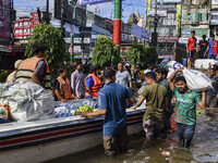 Volunteers wade through floodwaters to transport relief material for flood-affected people in Feni district in Chittagong division, Banglade...