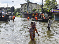 People wade through floodwaters in Feni district in Chittagong division, Bangladesh, on August 24, 2024. (