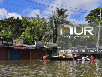 Volunteers wade through floodwaters to transport relief material for flood-affected people in Feni district in Chittagong division, Banglade...