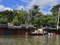 Volunteers wade through floodwaters to transport relief material for flood-affected people in Feni district in Chittagong division, Banglade...