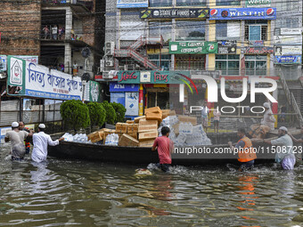 Volunteers wade through floodwaters to transport relief material for flood-affected people in Feni district in Chittagong division, Banglade...