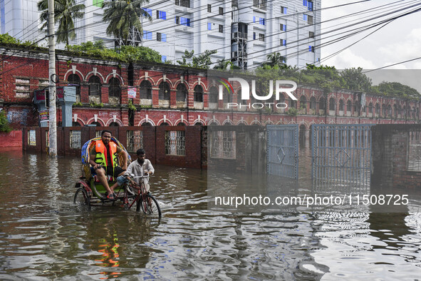 People wade through floodwaters in Feni district in Chittagong division, Bangladesh, on August 24, 2024. 