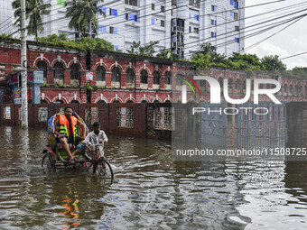 People wade through floodwaters in Feni district in Chittagong division, Bangladesh, on August 24, 2024. (