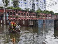 People wade through floodwaters in Feni district in Chittagong division, Bangladesh, on August 24, 2024. (