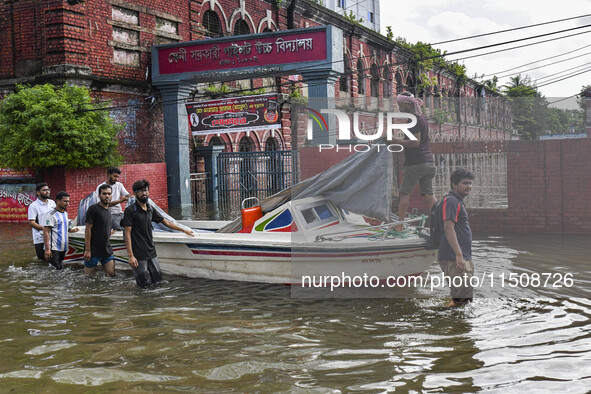 People wade through floodwaters in Feni district in Chittagong division, Bangladesh, on August 24, 2024. 