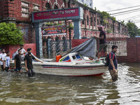 People wade through floodwaters in Feni district in Chittagong division, Bangladesh, on August 24, 2024. (