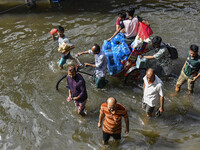 People wade through floodwaters in Feni district in Chittagong division, Bangladesh, on August 24, 2024. (