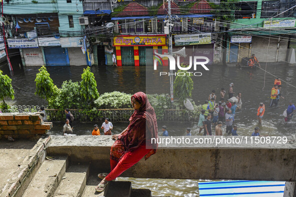 A woman takes temporary shelter at an under-construction building in the Feni district in Chittagong division, Bangladesh, on August 24, 202...