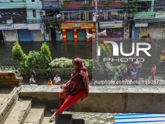 A woman takes temporary shelter at an under-construction building in the Feni district in Chittagong division, Bangladesh, on August 24, 202...