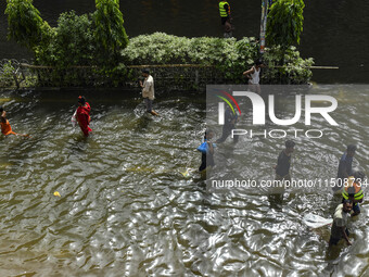 People wade through floodwaters in Feni district in Chittagong division, Bangladesh, on August 24, 2024. (