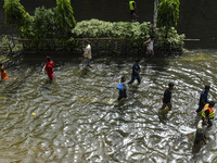 People wade through floodwaters in Feni district in Chittagong division, Bangladesh, on August 24, 2024. (