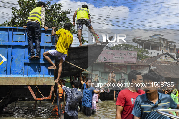 Volunteers unload a boat from a truck in Feni district in Chittagong division, Bangladesh, on August 24, 2024. 