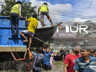 Volunteers unload a boat from a truck in Feni district in Chittagong division, Bangladesh, on August 24, 2024. (