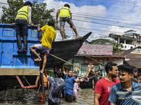 Volunteers unload a boat from a truck in Feni district in Chittagong division, Bangladesh, on August 24, 2024. (