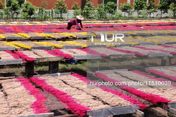 A worker dries incense on the drying field of a fragrance-making enterprise in Quanzhou, China, on August 25, 2024. 