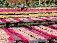 A worker dries incense on the drying field of a fragrance-making enterprise in Quanzhou, China, on August 25, 2024. (