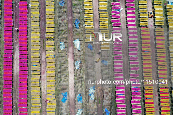 A worker dries incense on the drying field of a fragrance-making enterprise in Quanzhou, China, on August 25, 2024. 