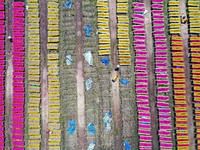 A worker dries incense on the drying field of a fragrance-making enterprise in Quanzhou, China, on August 25, 2024. (