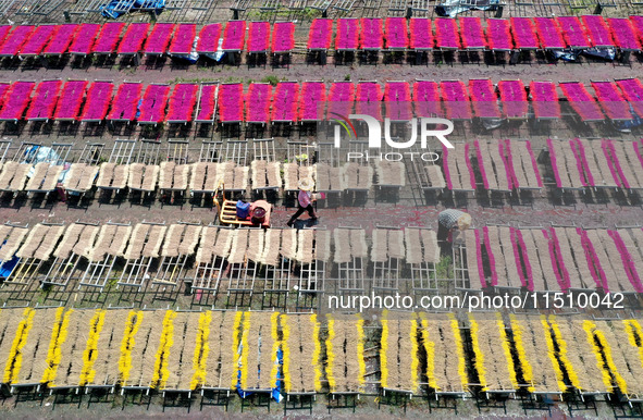 A worker dries incense on the drying field of a fragrance-making enterprise in Quanzhou, China, on August 25, 2024. 