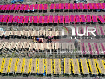 A worker dries incense on the drying field of a fragrance-making enterprise in Quanzhou, China, on August 25, 2024. (