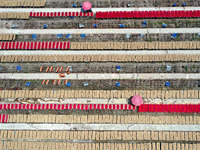 A worker dries incense on the drying field of a fragrance-making enterprise in Quanzhou, China, on August 25, 2024. (