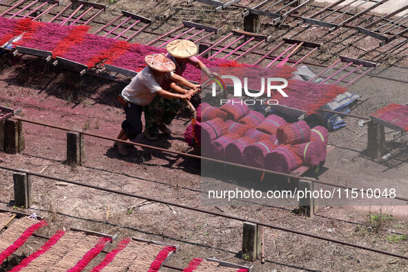 A worker dries incense on the drying field of a fragrance-making enterprise in Quanzhou, China, on August 25, 2024. 