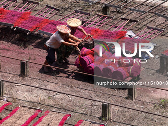 A worker dries incense on the drying field of a fragrance-making enterprise in Quanzhou, China, on August 25, 2024. (