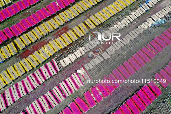 A worker dries incense on the drying field of a fragrance-making enterprise in Quanzhou, China, on August 25, 2024. 