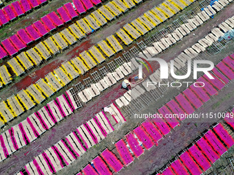 A worker dries incense on the drying field of a fragrance-making enterprise in Quanzhou, China, on August 25, 2024. (