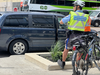 A parking enforcement officer issues parking tickets for illegal parking of cars on the side of the street in Toronto, Ontario, Canada, on A...