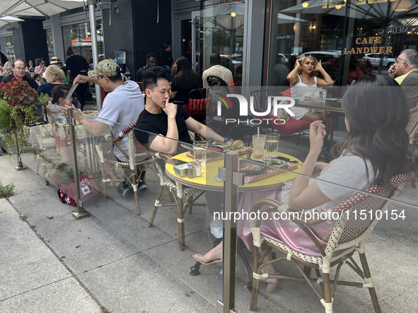 People dine on an outdoor restaurant patio in Toronto, Ontario, Canada, on August 24, 2024. 