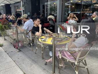 People dine on an outdoor restaurant patio in Toronto, Ontario, Canada, on August 24, 2024. (