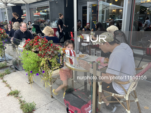 People dine on an outdoor restaurant patio in Toronto, Ontario, Canada, on August 24, 2024. 