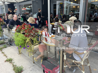 People dine on an outdoor restaurant patio in Toronto, Ontario, Canada, on August 24, 2024. (