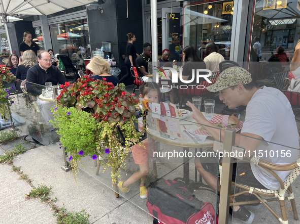 People dine at an outdoor restaurant patio in Toronto, Ontario, Canada, on August 24, 2024. 