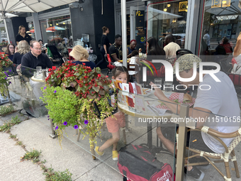 People dine at an outdoor restaurant patio in Toronto, Ontario, Canada, on August 24, 2024. (