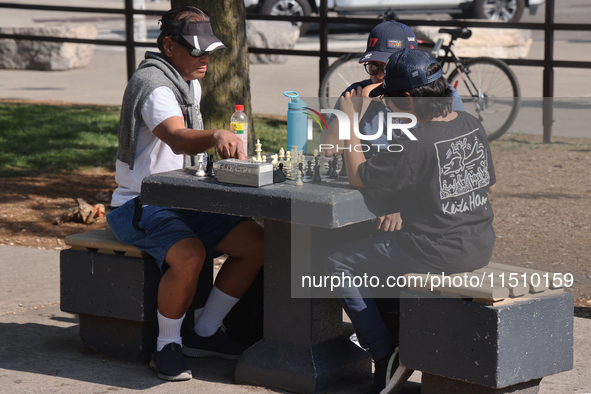 People play chess at Nathan Philips Square in downtown Toronto, Ontario, Canada, on August 14, 2024. 