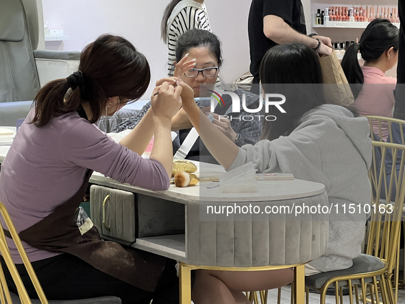 A manicurist shapes the cuticles of a customer at a nail shop in Toronto, Ontario, Canada, on May 25, 2024. 