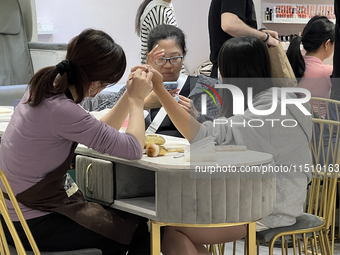 A manicurist shapes the cuticles of a customer at a nail shop in Toronto, Ontario, Canada, on May 25, 2024. (