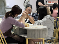 A manicurist shapes the cuticles of a customer at a nail shop in Toronto, Ontario, Canada, on May 25, 2024. (