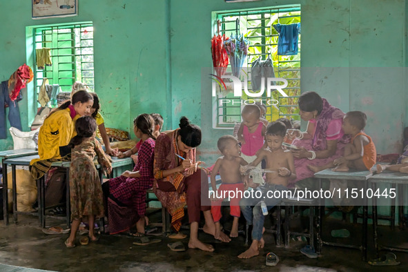 Children take shelter in a primary school during a flood in Feni, Bangladesh, on August 25, 2024. 