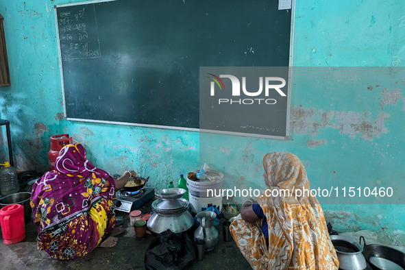 Women cook food inside a school room as they take shelter during the flood in Feni, Bangladesh, on August 25, 2024. 