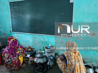 Women cook food inside a school room as they take shelter during the flood in Feni, Bangladesh, on August 25, 2024. (