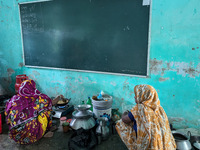 Women cook food inside a school room as they take shelter during the flood in Feni, Bangladesh, on August 25, 2024. (