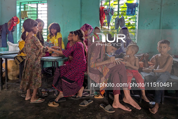 Children take shelter in a primary school during a flood in Feni, Bangladesh, on August 25, 2024. 