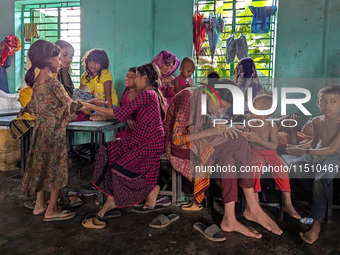 Children take shelter in a primary school during a flood in Feni, Bangladesh, on August 25, 2024. (