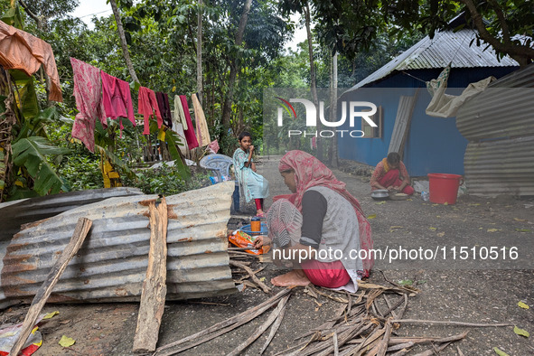 People cook food on the street during a flood in Feni, Bangladesh, on August 25, 2024. 